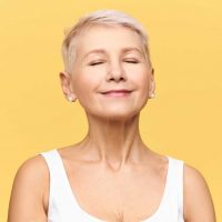 fashionable-beautiful-retired-caucasian-woman-with-pixie-hairdo-wearing-casual-clothes-posing-keeping-eyes-closed-smiling-with-pleasure-enjoyment-listening-good-music-dreaming