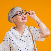 portrait-attractive-funky-asian-tattoo-cheerful-greyhaired-elder-old-senior-woman-touching-spectacles-isolated-yellow-pastel-background-colorsurprise-exited-feeling-expression (1)