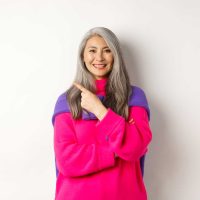 portrait-happy-asian-senior-woman-smiling-pointing-upper-left-corner-looking-satisfied-demonstrate-special-promotion-standing-white-background